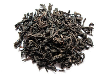 Black dry tea leaves isolated on white background. View from above