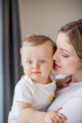 Beautiful mother and little son 9 months in the home interior. Cozy. Baby. Motherhood.