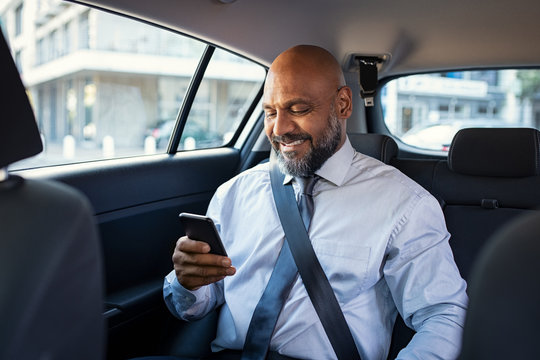 Mature business man using phone in car
