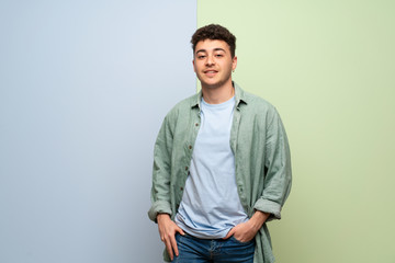 Fototapeta premium Young man over blue and green background With happy expression