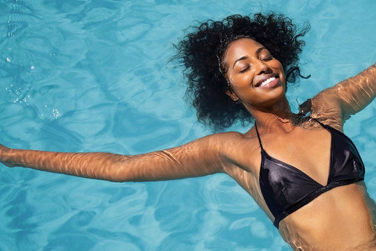 African woman relaxing in swimming pool