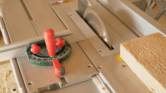 Circular in action. Woodworker rip cut saws ash plank on a table saw. Joiner at work.