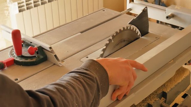 Circular in action. Woodworker rip cut saws ash plank on a table saw. Joiner at work.