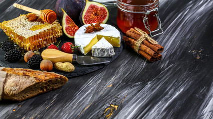 Camembert with figs and hone. cheese platter, snacks, on old wooden table. top view. copy space