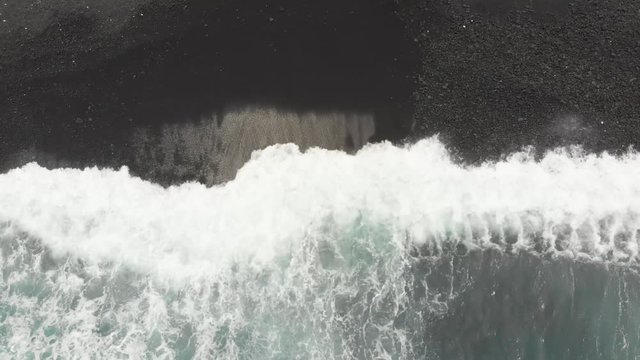beautiful calming visual of a black sand beach in hawaii