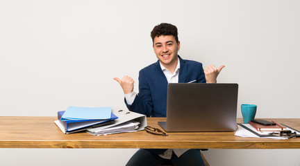 Business man in a office with thumbs up gesture and smiling