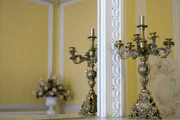 Antique candelabrum on mirror in the room. An ancient candlestick in the interior. 