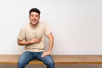 Young man sitting on table smiling a lot