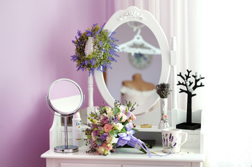wedding bouquet and cup of tea on the bedside table with mirror