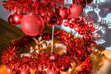 Fototapeta na wymiar Modern metal spiral Christmas tree decorated with red shiny balls