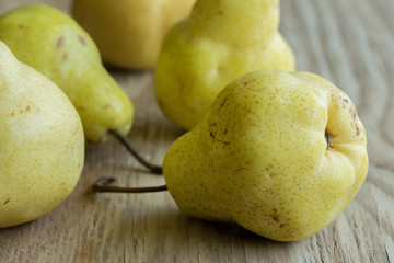 Ripe yellow Bartlett pears in a group on rough wooden texture