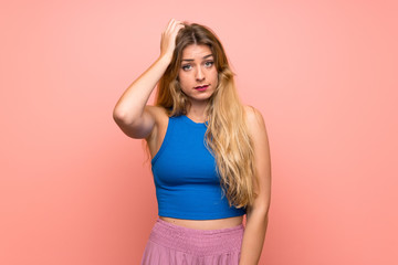 Young blonde woman over isolated pink background with an expression of frustration and not understanding
