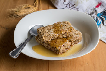 Wheat cereal bars dribbled with honey - Breakfast cereal in a white bowl