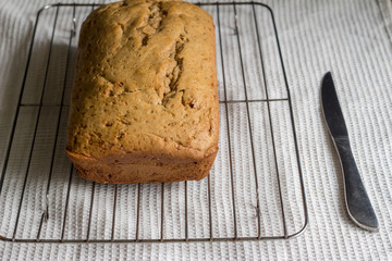 Banana bread cake on cake grid on white dishtowel background