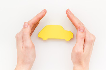 Car insurance concept with car in hands on white background top view mockup