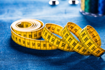 background table top view of sewing tool and jeans on denim fabric