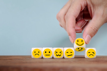 Hand Changing with smile emoticon icons  face on Wooden Cube , hand flipping unhappy turning to...