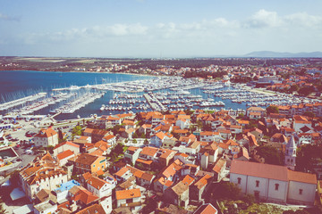 Fototapeta na wymiar Aerial View of Yacht Club and Marina in Biograd na Moru. Summer time in Dalmatia region of Croatia. Coastline and turquoise water and blue sky. Photo made by drone from above.