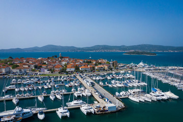 Fototapeta na wymiar Aerial View of Yacht Club and Marina in Biograd na Moru. Summer time in Dalmatia region of Croatia. Coastline and turquoise water and blue sky. Photo made by drone from above.