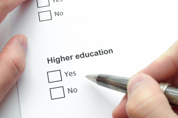 Higher education. A man fills a checklist, holds a pen in his hand