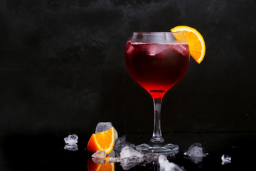 Fresh red colorful exotic alcoholic cocktail with lemon and ice