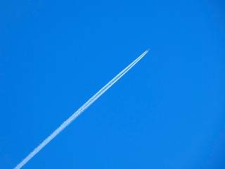 avión sobrevolando el cielo azul, dejando una estela
