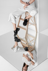 Young model in vogue outfit on chair