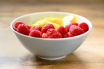 Ananasstücke und Himbeeren in einer Schale