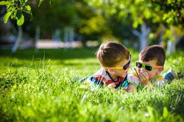 Fototapeta premium Happy smiling boy sibling brother relaxing on the grass. Close up view with copy space.