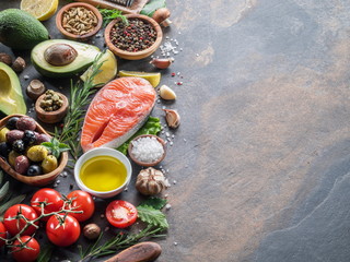 Raw salmon with spices and vegetables on the graphite board.