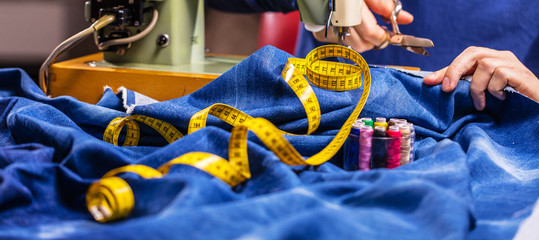 Sewing denim jeans with sewing machine. Repair jeans by sewing machine. Alteration jeans, hemming a...