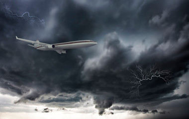 Fototapeta na wymiar Aircraft with dramatic sky and lightning, flying at bad weather with dark clouds
