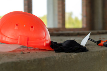 A pair of gloves and a Mason's helmet at the construction.