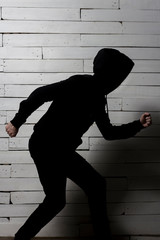 black silhouette of a running man against a white wooden wall
