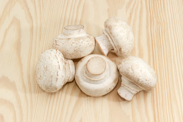 Fresh cultivated button mushrooms on a wooden surface