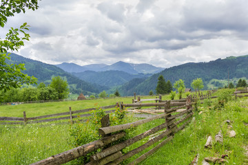 Mountain slope with fenced hayfields on a foreground
