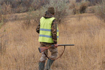Hunter with a german drathaar and spaniel, pigeon hunting with dogs in reflective vests	