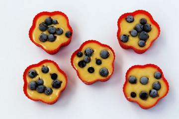 Preparation for baking muffins with currants, dough is spread out into silicone molds
