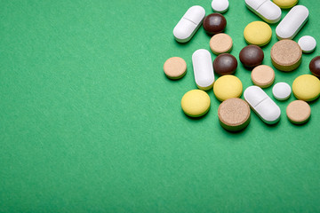 pills on a green background with copyspace macro wiew
