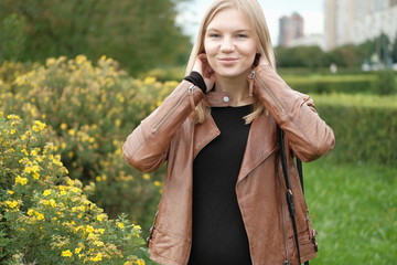 Beautiful blond girl posing for photo in park with wildberry