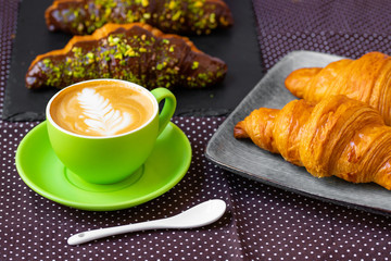 french breakfast. coffee with croissant. Cappuccino in a green cup with croissant.