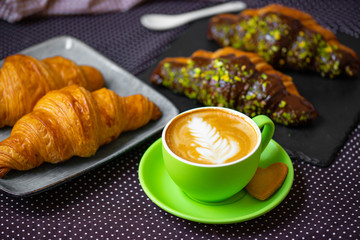 french breakfast. coffee with croissant. Cappuccino in a green cup with croissant.
