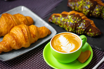 french breakfast. coffee with croissant. Cappuccino in a green cup with croissant.