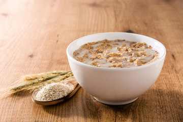 Oats milk and cereals on wooden table.