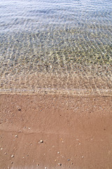 Exotic sandy beach, tropical blue mediterranean sea with waves and sea foam. Beautiful natural environment, panorama, landscape. Idyllic seaside resort in summer season, paradise and amazing scene.