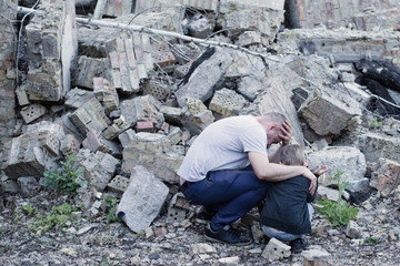 father and son among the ruins of a destroyed building