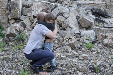 father and son among the ruins of a destroyed building
