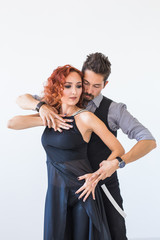 Social dance, bachata, kizomba, zouk, tango concept - Man hugs woman while dancing over white background in studio