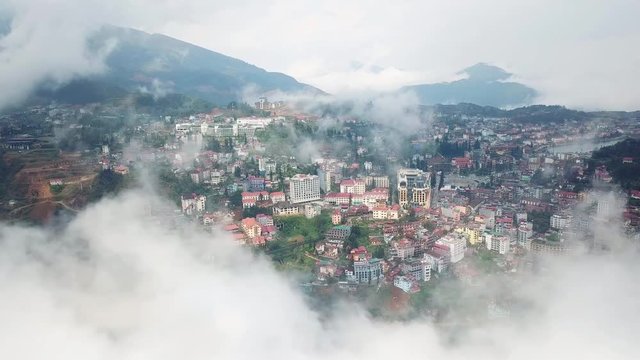Flight above center of the city in the clouds. Beautifull white smoke fog. Sapa Laocai Vietnam Asia. Summer sunny day. 
