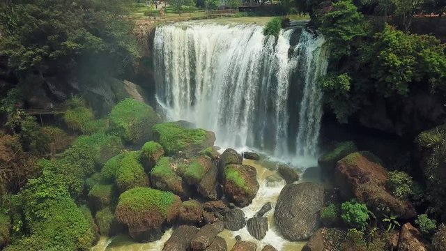 Drone backwards elephant full flowing waterfall stormy stones cobblestones moss Cam Ly River countryside village houses authentic. Natural landscape tropic exotic Sunny day Vietnam Dalat landmark